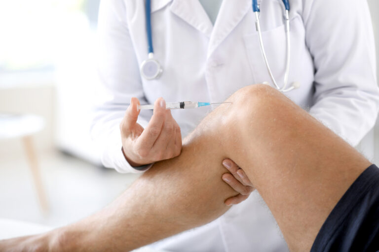 Doctor,Giving,Sportsman,With,Joint,Pain,Injection,In,Clinic,,Closeup